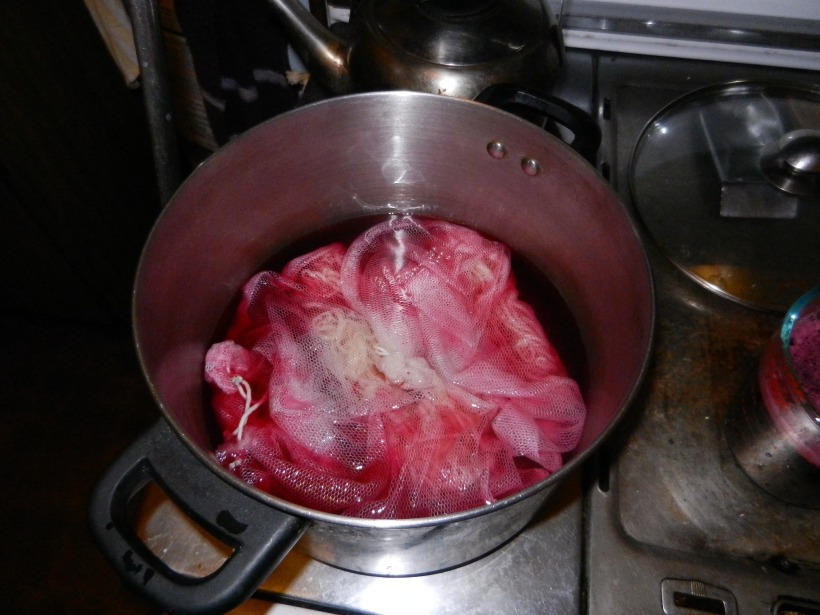 White yarn in pot with more bright fuschia dye.